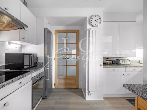 Modern kitchen with integrated appliances and granite worktop in an apartment in Mandelieu-la-Napoule.