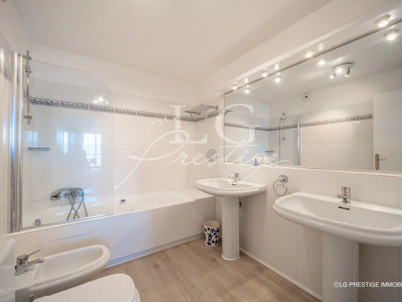 Modern bathroom with bathtub and double sink in an apartment in Mandelieu-la-Napoule.