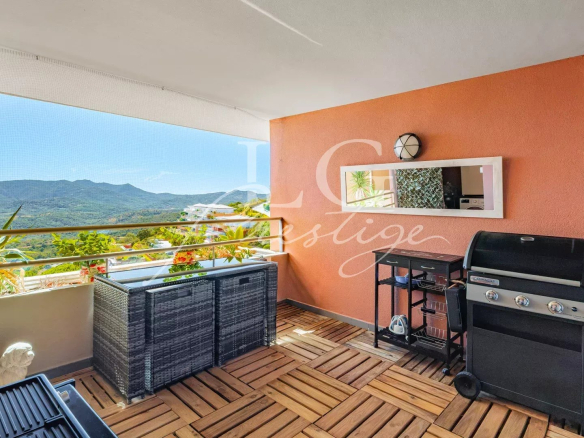Apartment terrace with sea and mountain views, garden furniture and barbecue.