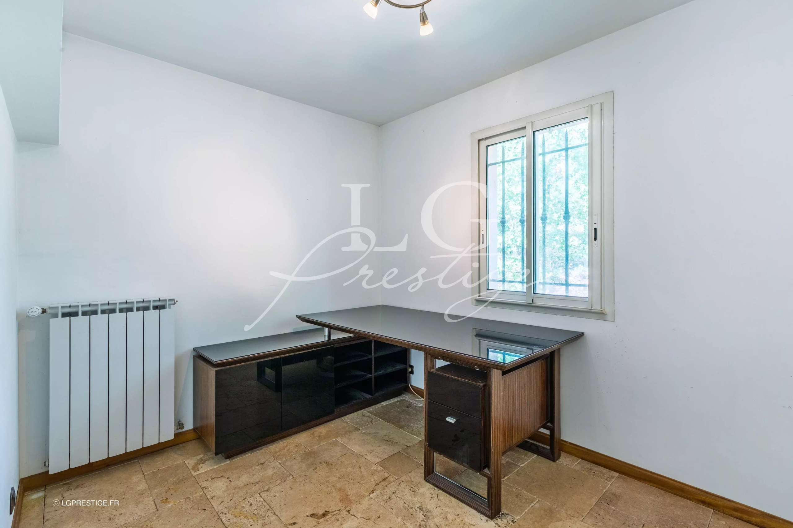 Bureau dans une bastide provençale à Fayence Bureau moderne avec un bureau en verre et une fenêtre, dans une maison à Fayence.