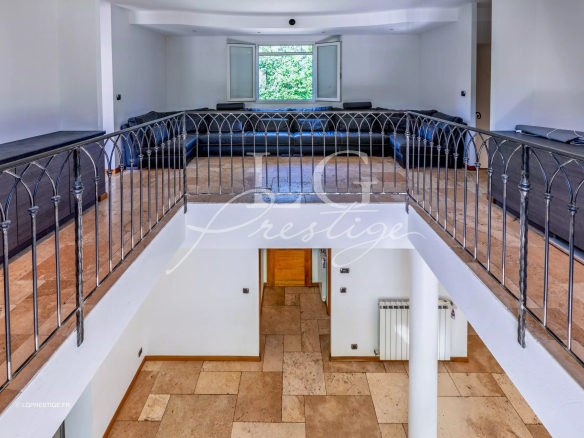 Intérieur d'une bastide provençale avec un grand salon et un balcon en fer forgé.