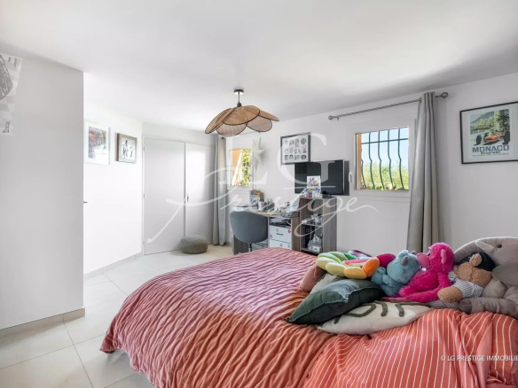 Bedroom in a villa in Spéracèdes with bed and stuffed animals, decorated with light colors.