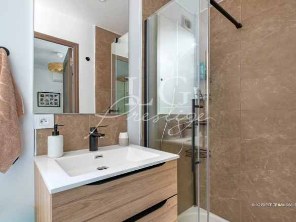 Modern bathroom with shower, sink and mirror in a renovated villa.
