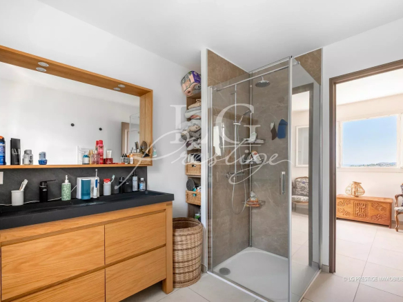 Modern bathroom with shower, mirror and wooden furniture.