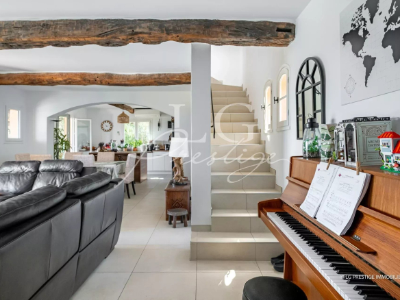 Interior of a renovated villa with living room, piano and staircase, sea view.
