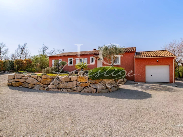 Maison de plain-pied avec jardin paysager et piscine à Callian, entourée d'arbres.
