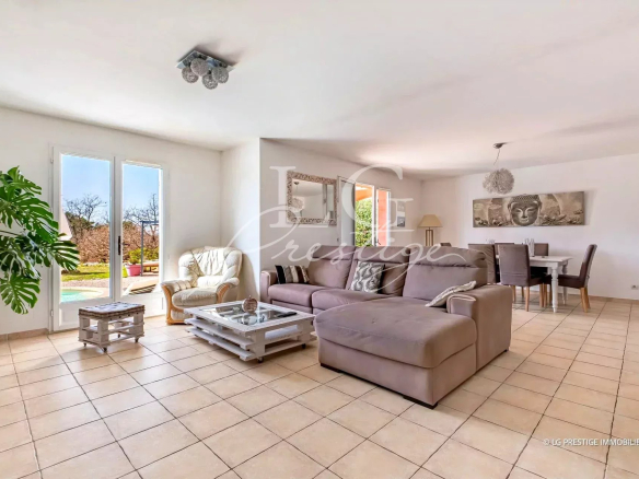Intérieur d'une villa de plain-pied avec salon lumineux et mobilier moderne.