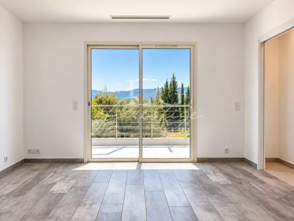 Interior of a contemporary villa with large bay windows and views of nature.