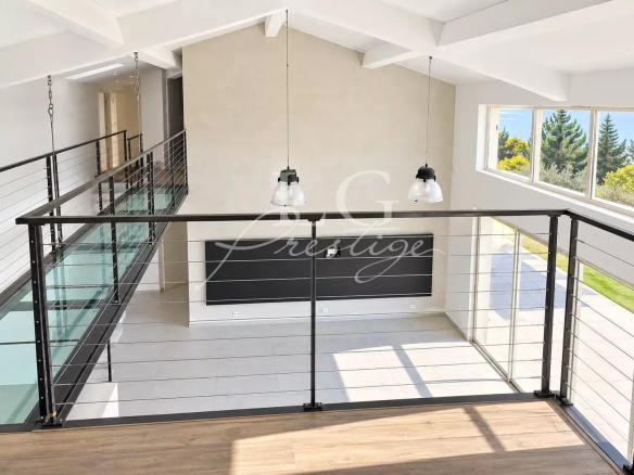 Interior view of a contemporary villa with mezzanine and cathedral-ceilinged living room.