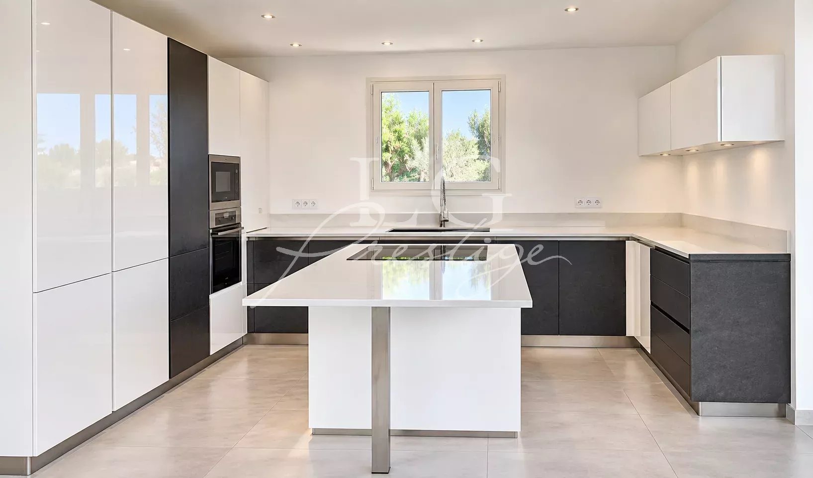 Kitchen of a contemporary villa in Montauroux Modern and bright kitchen of a contemporary villa in Montauroux, with central island and windows.