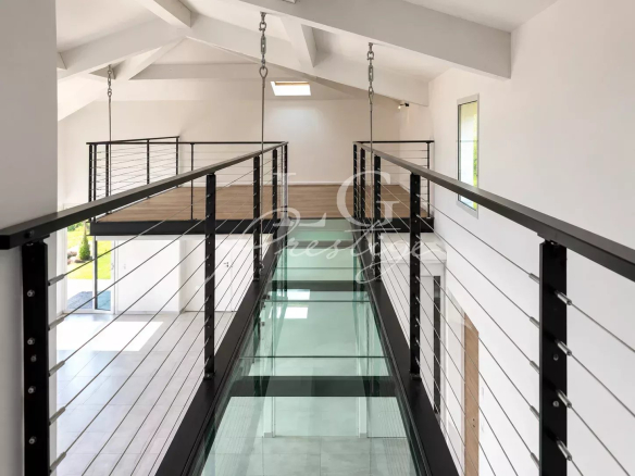 Interior of a contemporary villa with mezzanine and suspended walkway.