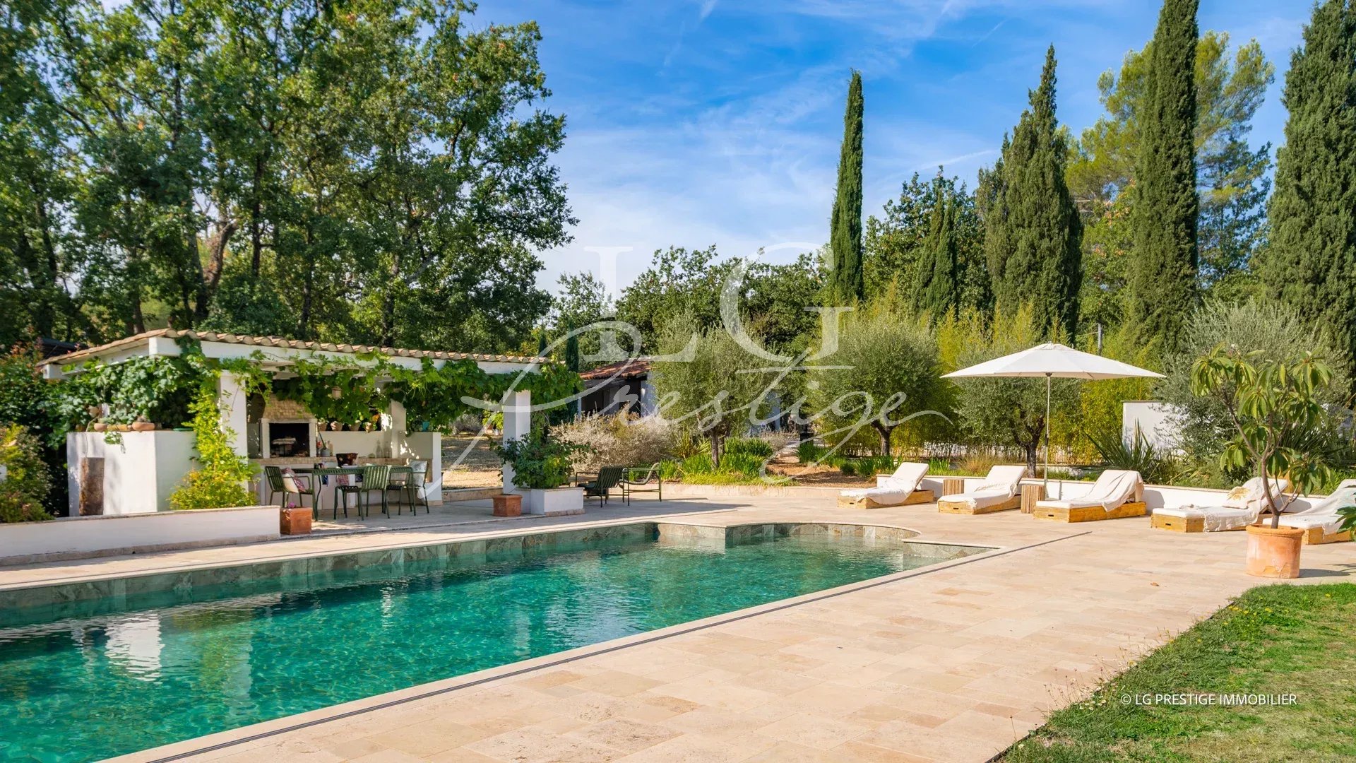 Propriété provençale avec piscine et espace extérieur à Fayence, entourée d'arbres et de verdure.