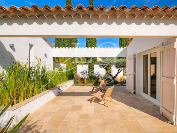 Terrasse d'une propriété provençale avec chaises en bois et végétation, Fayence