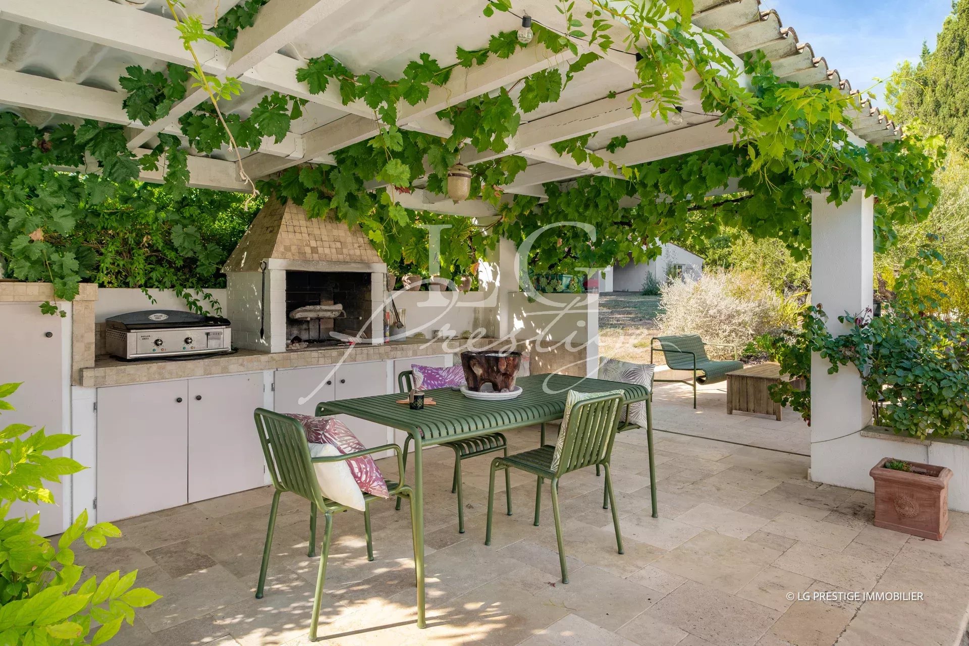 Terrasse extérieure avec barbecue et mobilier en Provence, entourée de verdure.