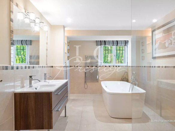 Salle de bain moderne avec baignoire et double vasque dans une villa à Mandelieu-la-Napoule.