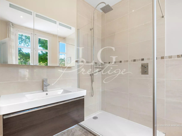 Salle de bain moderne avec douche et lavabo dans une villa à Mandelieu-la-Napoule.