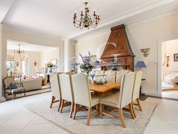 Salle à manger d'une villa de caractère à Mandelieu-la-Napoule, avec table en bois et chaises claires.