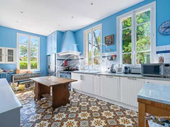 Cuisine lumineuse d'une villa à Mandelieu-la-Napoule avec fenêtres et carrelage coloré.