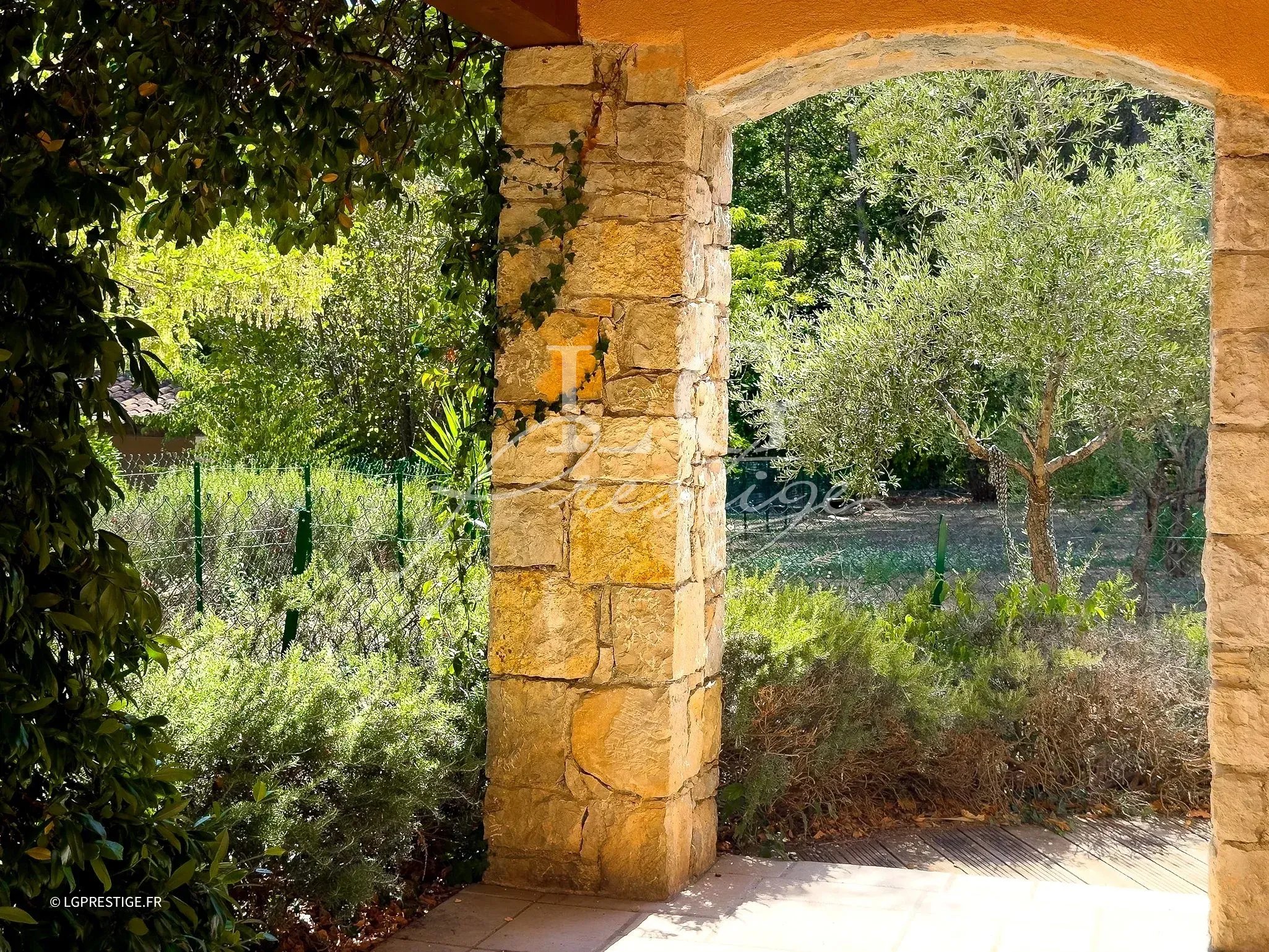 Vue d'une bastide provençale avec jardin paysager et piscine, entourée de verdure à Fayence.