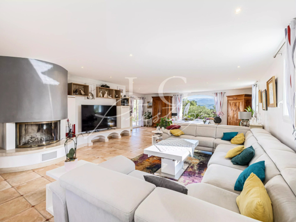 Intérieur d'une villa spacieuse avec un salon lumineux et un coin cheminée.