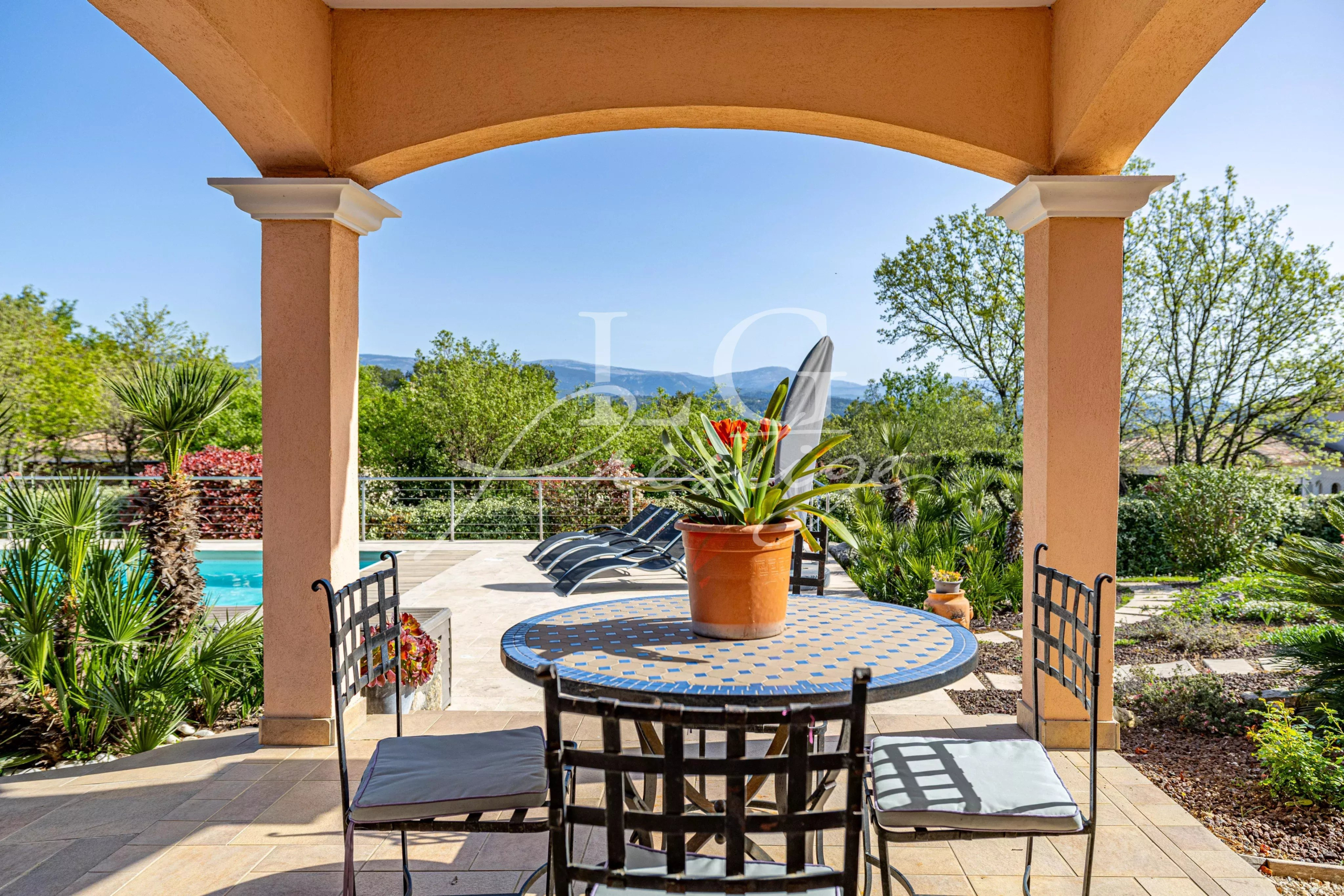 Terrasse de villa avec piscine Terrasse d'une villa avec table et chaises, vue sur piscine et paysage verdoyant à Fayence.