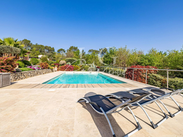 Piscine d'une villa avec chaises longues et jardin paysagé à Fayence.