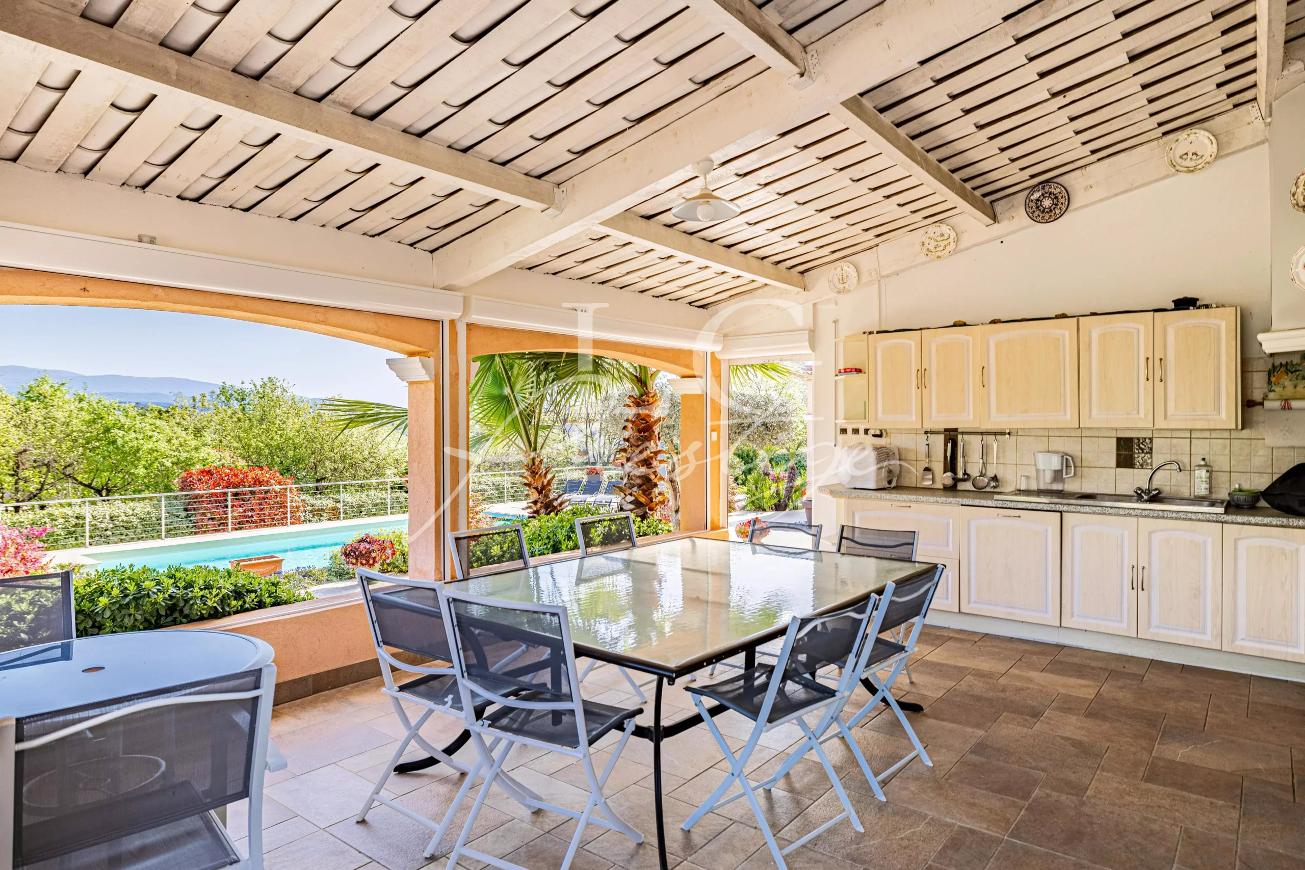 Terrasse de la villa à Fayence Terrasse couverte avec table et chaises, vue sur la piscine et le jardin de la villa à Fayence.