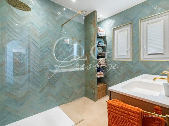 Modern bathroom with mosaic tiles and double sink.
