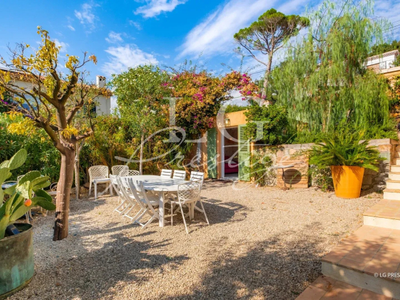 Garden of a villa in Mandelieu-la-Napoule with outdoor table and chairs.
