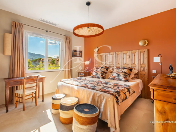 Room in a villa in Mandelieu-la-Napoule with bed, desk and warm decor.