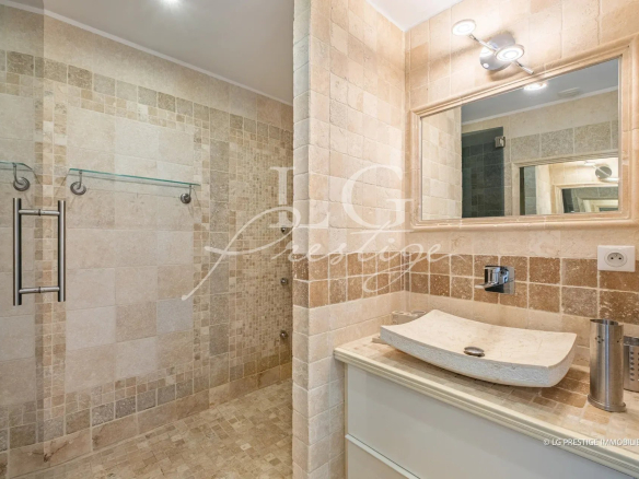 Salle de bain moderne avec douche à l'italienne et meuble vasque en pierre.