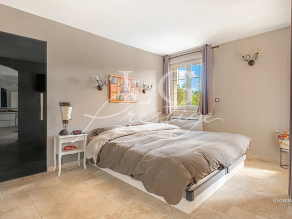 Chambre d'une villa élégante à Callian, avec lit double et décoration sobre.