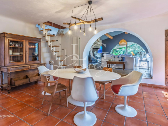 Interior of a Provençal villa with dining room and fireplace, natural light.