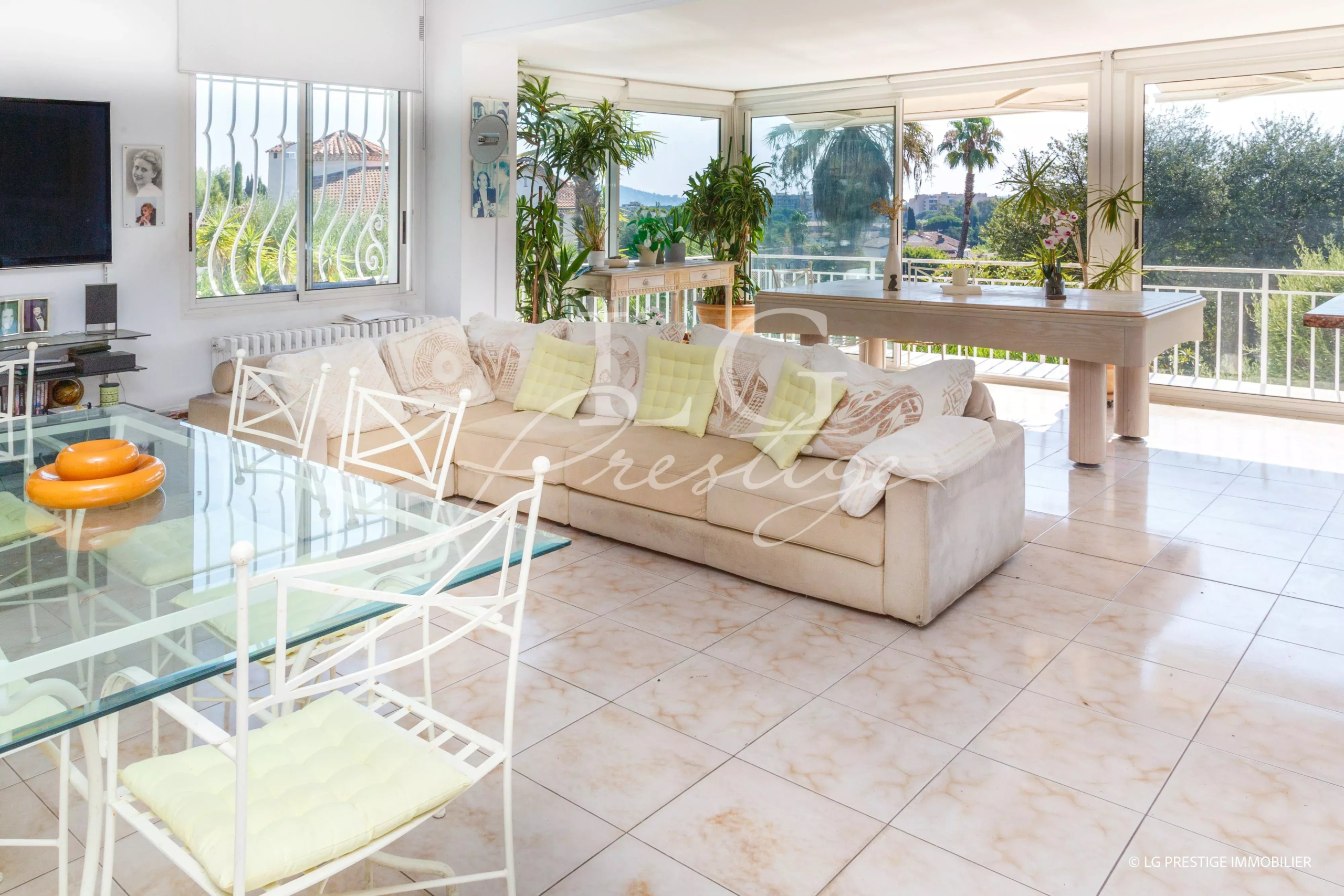 Intérieur d'une villa spacieuse avec salon lumineux et vue sur le jardin.