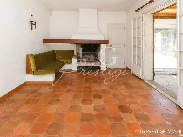 Interior of a villa to be renovated with a bright living room and a lounge area, terracotta tiles.