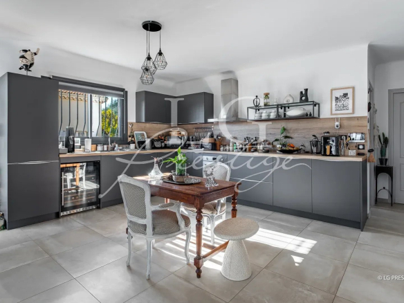 Cuisine moderne dans une maison rénovée à Mandelieu-la-Napoule, avec table et chaises.