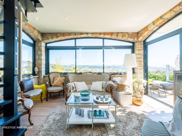 Intérieur d'une maison rénovée avec vue sur la mer et les montagnes, salon lumineux et décoré.