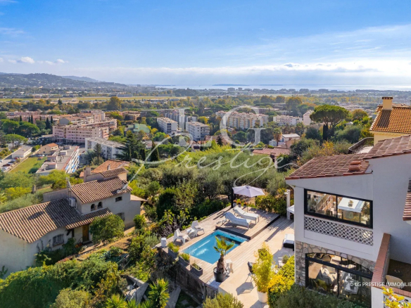 Vue panoramique d'une maison rénovée à Mandelieu-la-Napoule avec piscine et jardin.