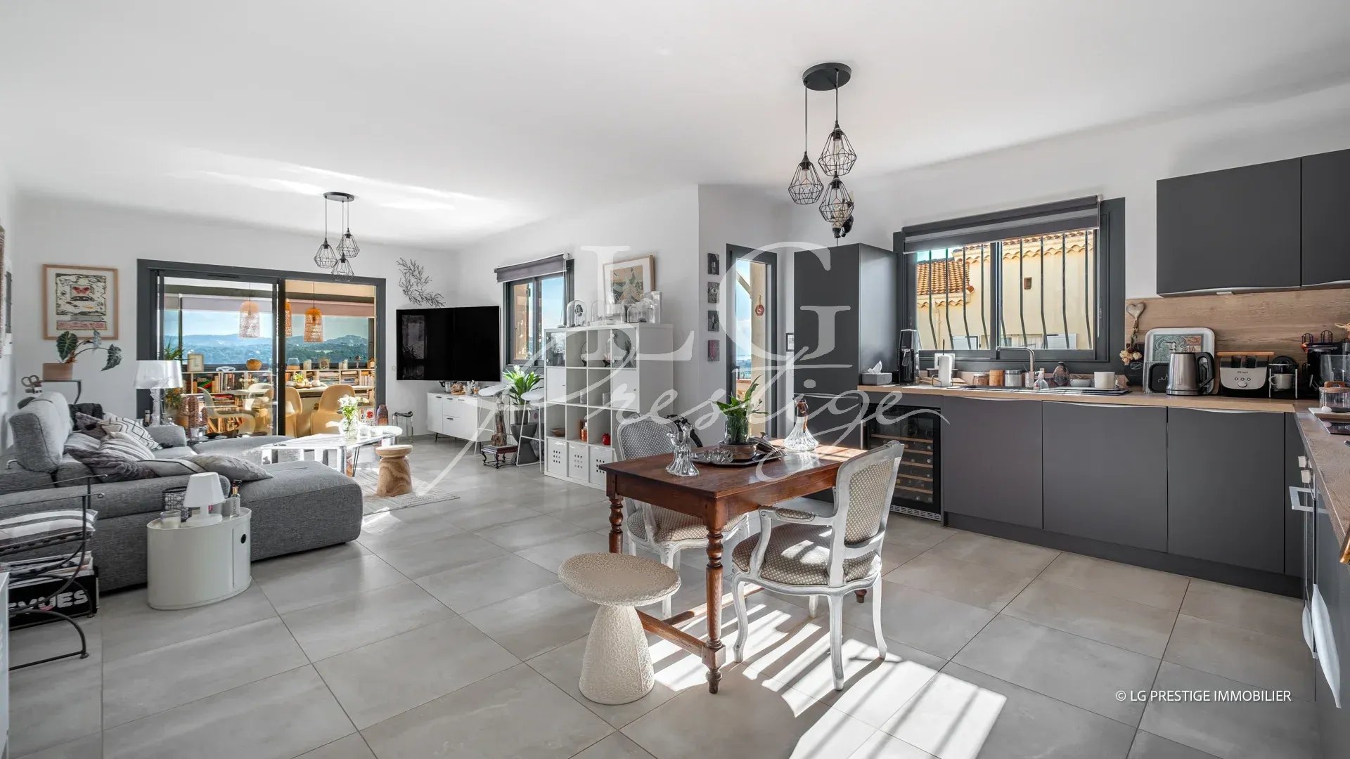 Intérieur d’une maison rénovée à Mandelieu-la-Napoule Intérieur d'une maison moderne avec cuisine ouverte et salon, vue sur la mer et les montagnes.