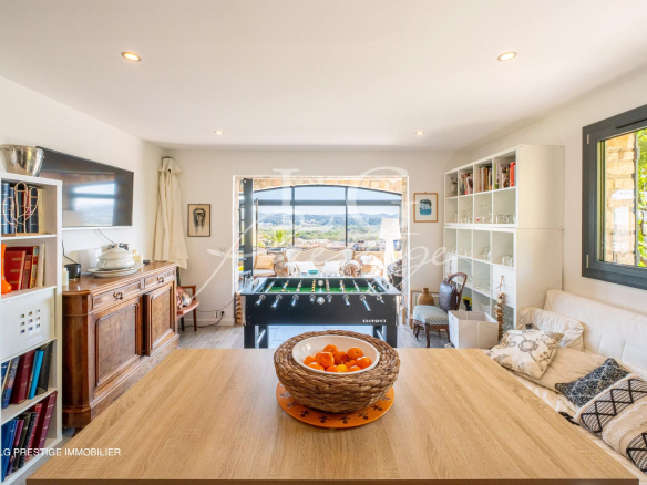 Intérieur d'une maison rénovée avec vue sur la mer et les montagnes, salon lumineux et mobilier moderne.