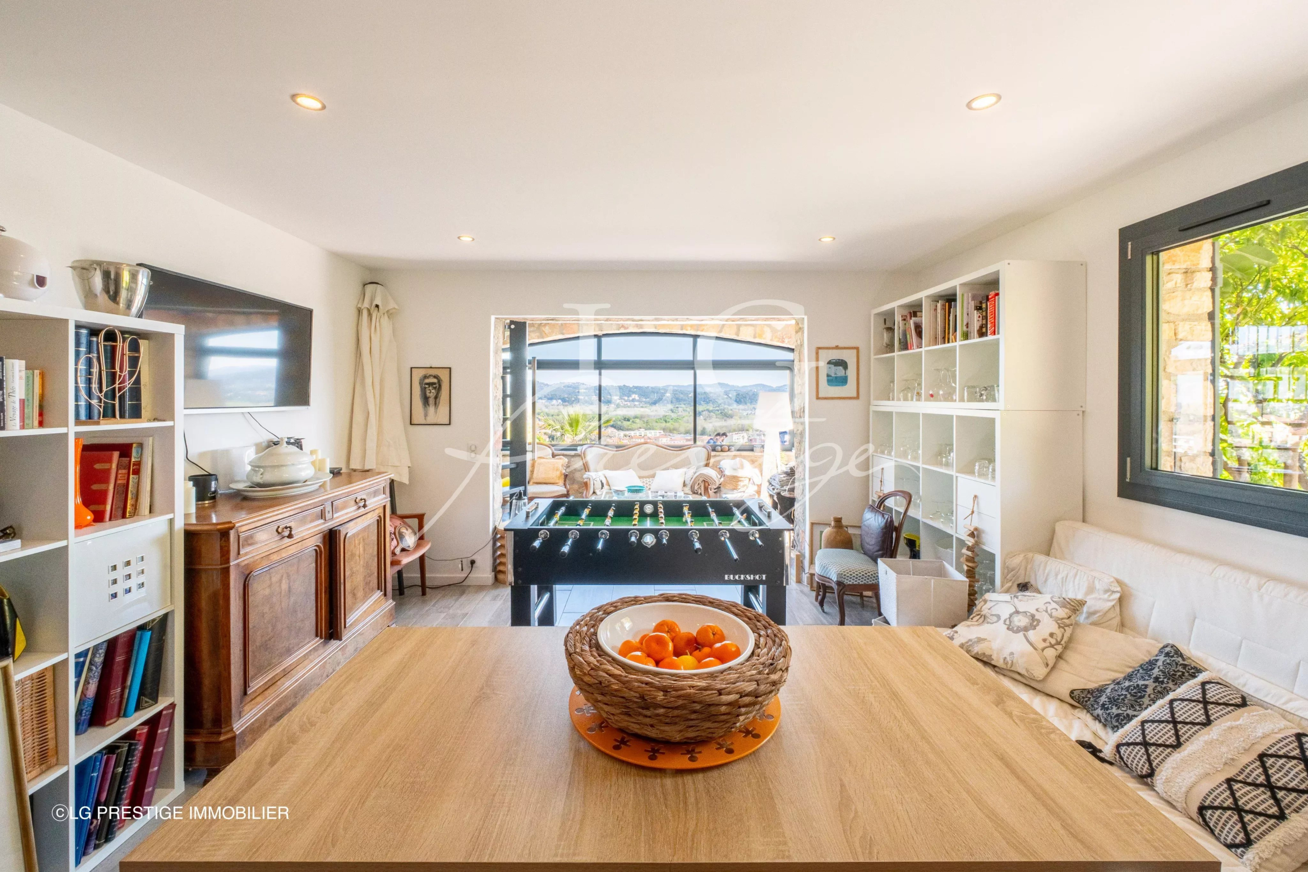 Intérieur d’une maison rénovée à Mandelieu-la-Napoule Intérieur d'une maison rénovée avec vue sur la mer et les montagnes, salon lumineux et mobilier moderne.