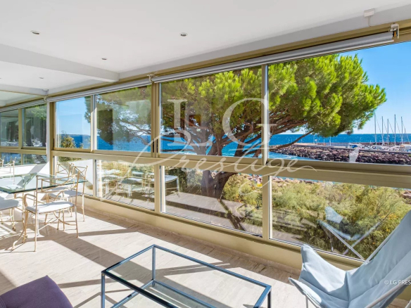 Vue panoramique sur la mer depuis un appartement lumineux avec de grandes fenêtres.