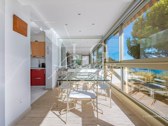 Intérieur d'un appartement avec vue mer, cuisine équipée et espace de vie lumineux.