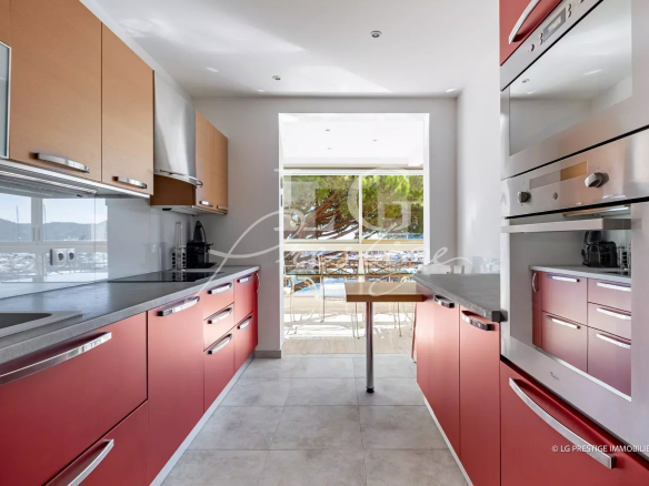Cuisine moderne d'un appartement à Mandelieu-La-Napoule, vue sur la mer depuis la fenêtre.