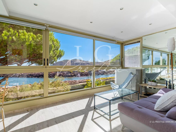 Intérieur d'un appartement à Mandelieu-La-Napoule avec vue mer, fenêtres panoramiques et mobilier moderne.