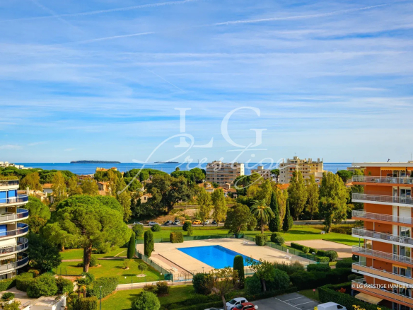 Vue panoramique d'un appartement en bord de mer à Mandelieu-la-Napoule avec piscine et jardins.