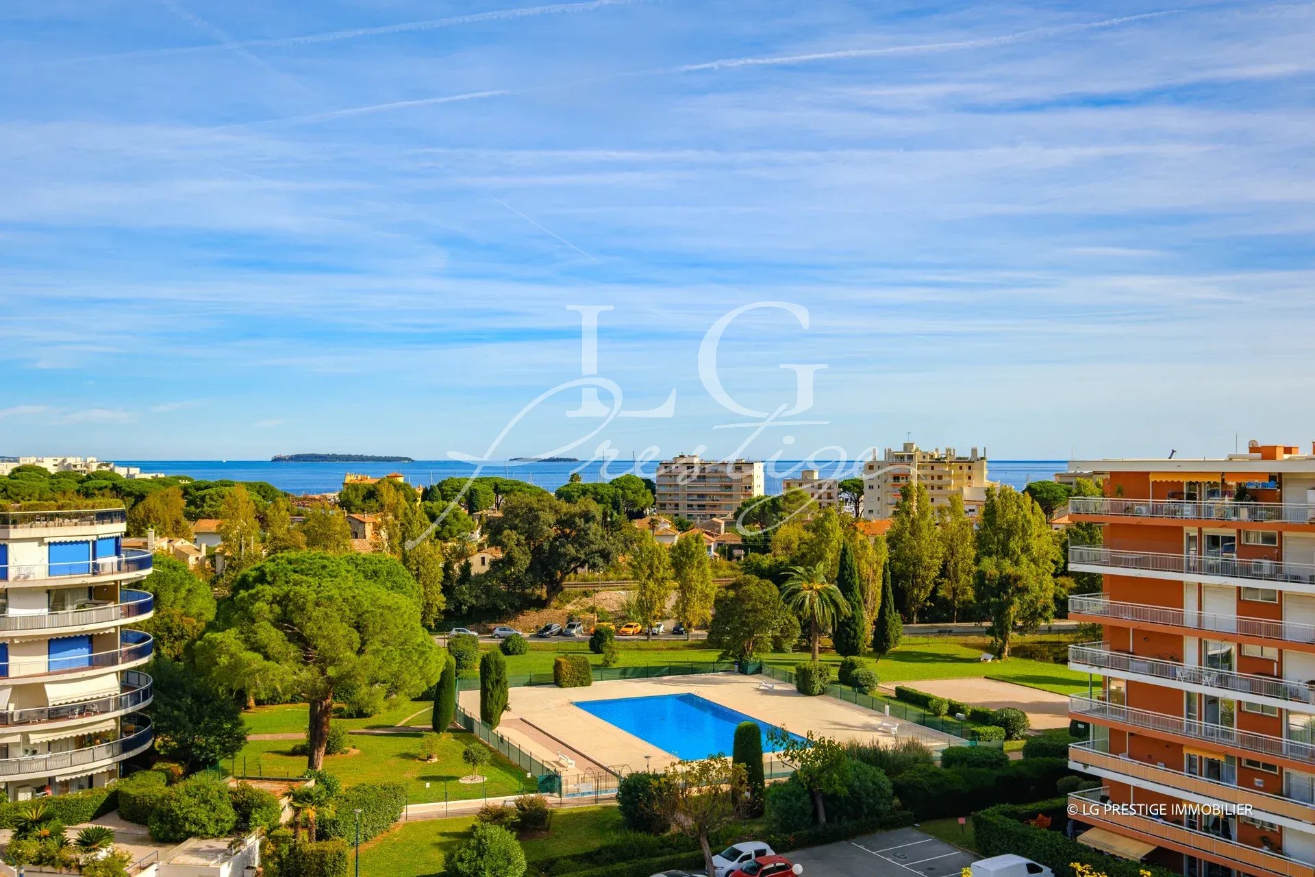 Vue panoramique d'un appartement en bord de mer à Mandelieu-la-Napoule avec piscine et jardins.