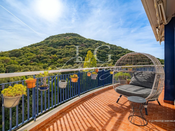 Terrasse d'un appartement avec vue sur une colline verdoyante à Mandelieu-la-Napoule.