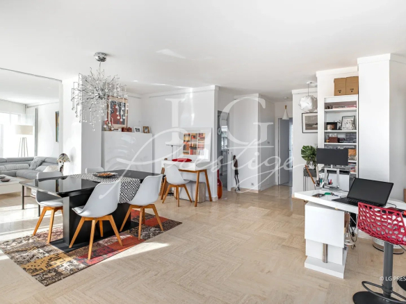 Intérieur d'un appartement lumineux avec salle à manger et salon, vue sur la terrasse.