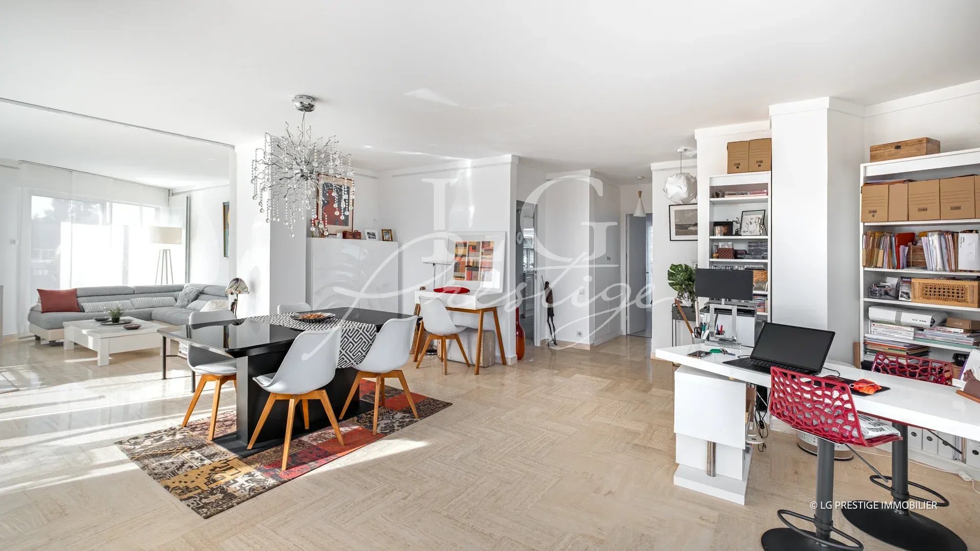 Intérieur d'un appartement lumineux avec salle à manger et salon, vue sur la terrasse.